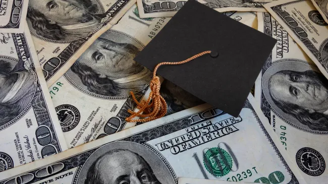 graduation cap on money